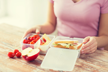 Image showing close up of woman with food in plastic container