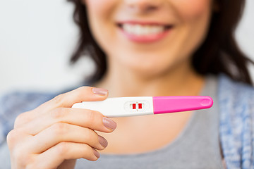 Image showing close up of happy woman with home pregnancy test