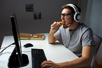 Image showing man in headset playing computer video game at home