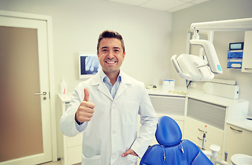 Image showing happy male dentist showing thumbs up at clinic