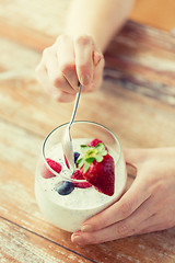 Image showing close up of woman hands with yogurt and berries