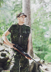 Image showing young soldier or hunter with gun in forest