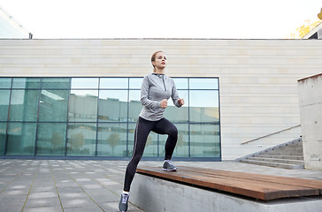 Image showing woman making step exercise on city street bench