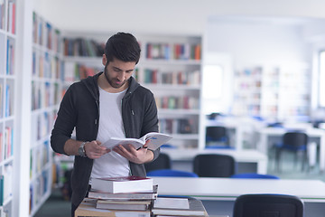 Image showing portrait of student while reading book  in school library