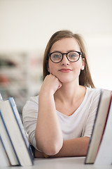 Image showing portrait of famale student selecting book to read in library