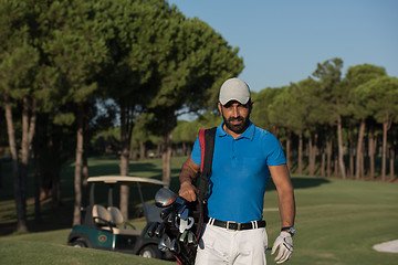 Image showing golfer  walking and carrying golf  bag