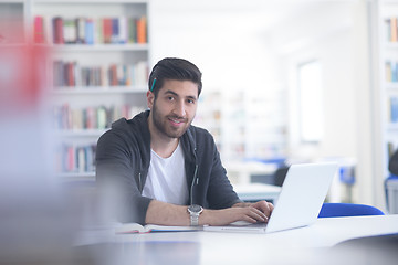 Image showing student in school library using laptop for research