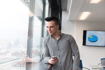 Image showing young business man using smart phone at office