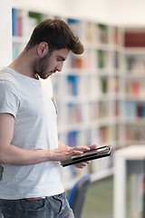 Image showing student in school library using tablet for research