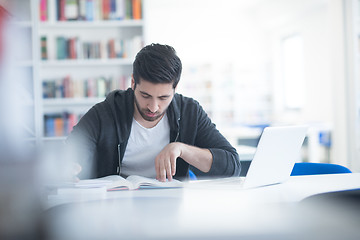 Image showing student in school library using laptop for research