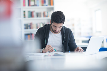 Image showing student in school library using laptop for research