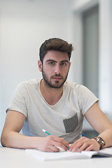 Image showing male student taking notes in classroom