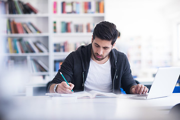 Image showing student in school library using laptop for research