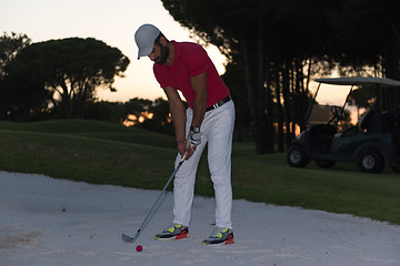 Image showing golfer hitting a sand bunker shot on sunset