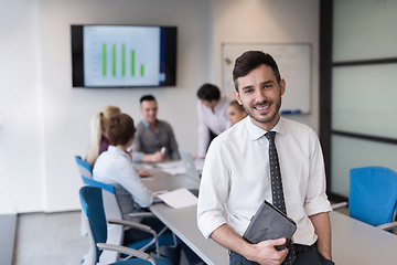 Image showing young business man with tablet at office meeting room