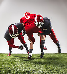 Image showing The three american football players in action