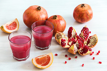 Image showing Pomegranate liqueur in a glasses on wooden table. Selective focus.