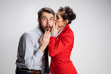 Image showing Young man telling gossips to his woman colleague at the office