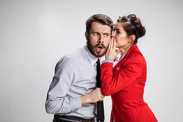 Image showing Young man telling gossips to his woman colleague at the office