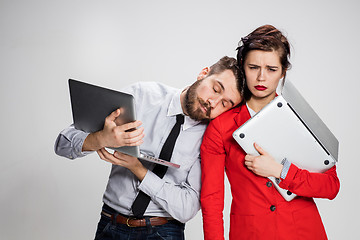 Image showing The young businessman and businesswoman with laptops on gray background