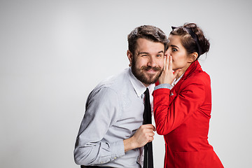 Image showing Young man telling gossips to his woman colleague at the office