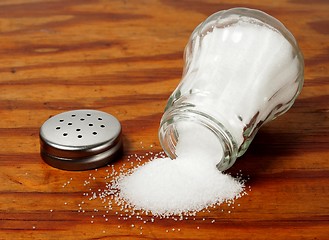 Image showing Salt shaker on wooden table