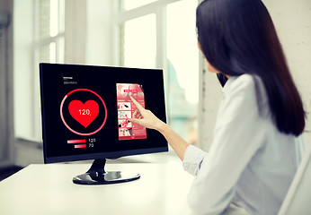 Image showing close up of woman with heart pulse on computer