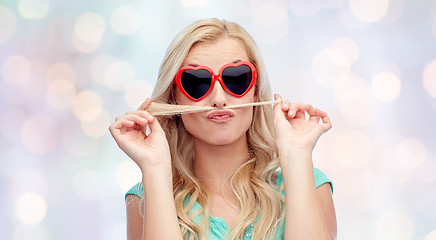 Image showing happy young woman making mustache with her hair