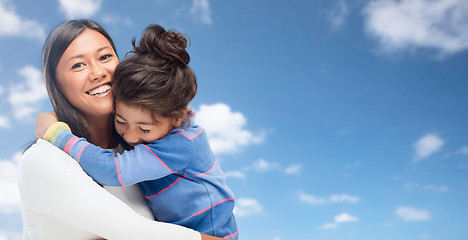 Image showing hugging mother and daughter over sky background