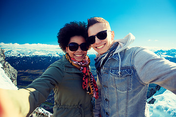 Image showing happy teenage couple taking selfie over mountains