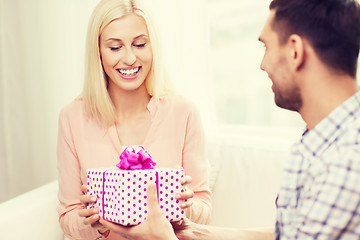 Image showing happy man giving woman gift box at home