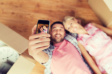 Image showing couple taking selfie with smartphone on floor