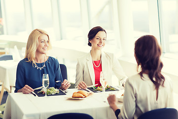 Image showing happy women eating and talking at restaurant