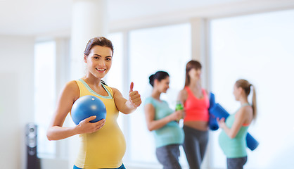 Image showing pregnant woman with ball in gym showing thumbs up 