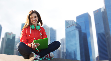 Image showing happy young woman with tablet pc and headphones