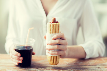 Image showing close up of woman with hot dog and coca drink