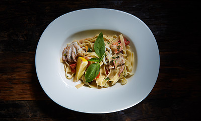 Image showing Fettuccine pasta  with shrimps, lemon, baby octopus, fresh Parmesan cheese, and  oregano. 