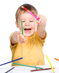 Image showing Little boy is playing with color pencils