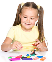 Image showing Little girl is playing with plasticine