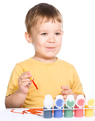 Image showing Little boy is playing with paints