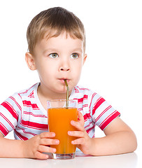 Image showing Little boy with glass of carrot juice