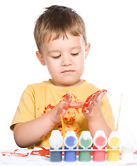 Image showing Little boy is playing with paints