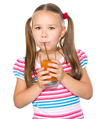 Image showing Little girl is drinking carrot juice