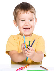 Image showing Little boy is playing with color pencils