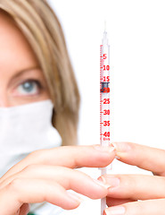 Image showing Young nurse is preparing syringe for injection