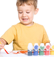 Image showing Little boy is playing with paints