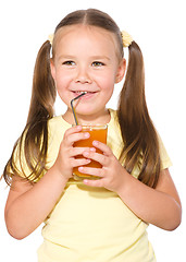 Image showing Little girl is drinking carrot juice