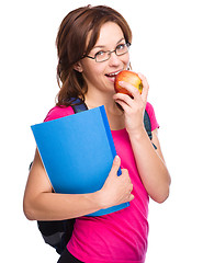 Image showing Young student girl is holding book and apple