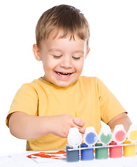 Image showing Little boy is playing with paints