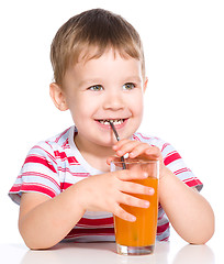 Image showing Little boy with glass of carrot juice